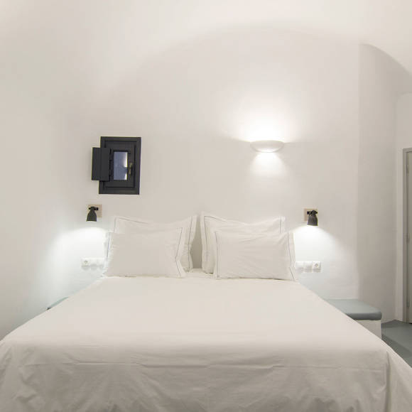 Grand Ambassador Santorini Serenity Two Bedroom Suite second bedroom with double bed, soft lighting, and Cycladic minimalist design