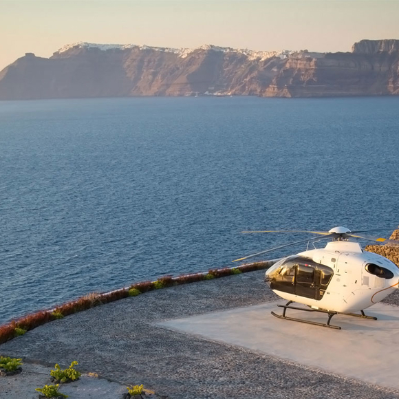 Helicopter on helipad overlooking sea and cliffs at Grand Ambassador hotel during sunset
