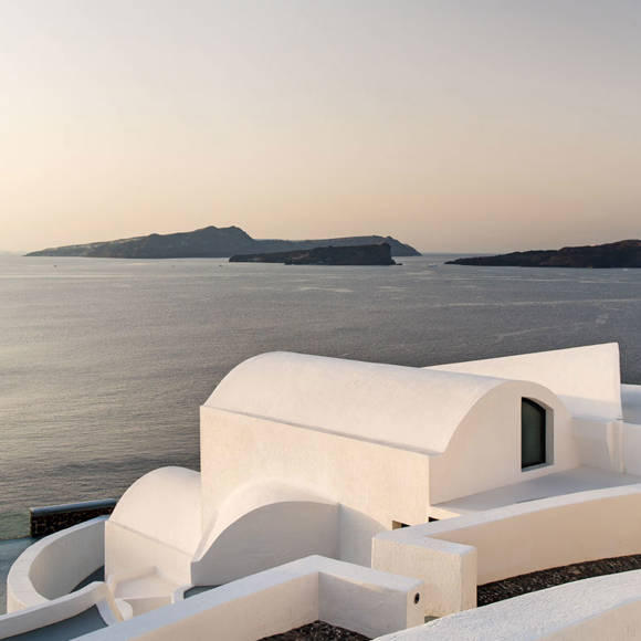 White curved rooftops overlooking calm sea and islands at sunset, scenic view from Grand Ambassador hotel