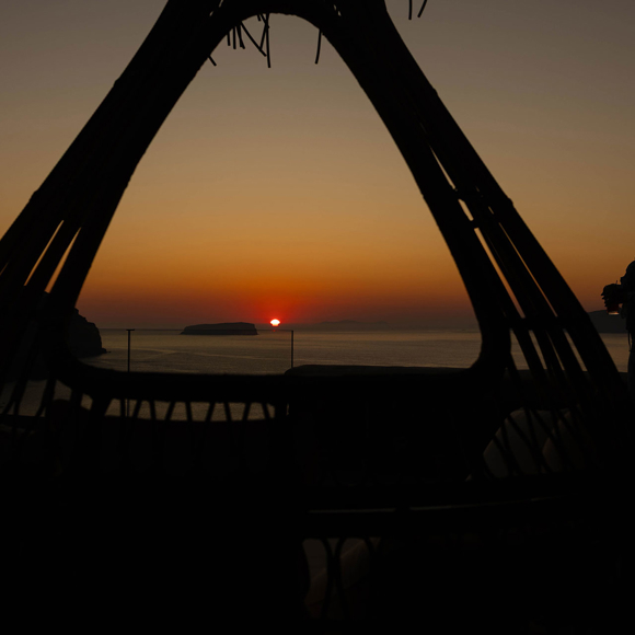 Guest watching sunset with drink at Grand Ambassador hotel terrace overlooking the sea