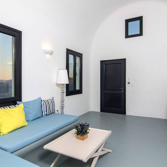 Grand Ambassador Santorini Serenity Two Bedroom Suite living area with sea view, modern built-in sofa, and colorful cushions