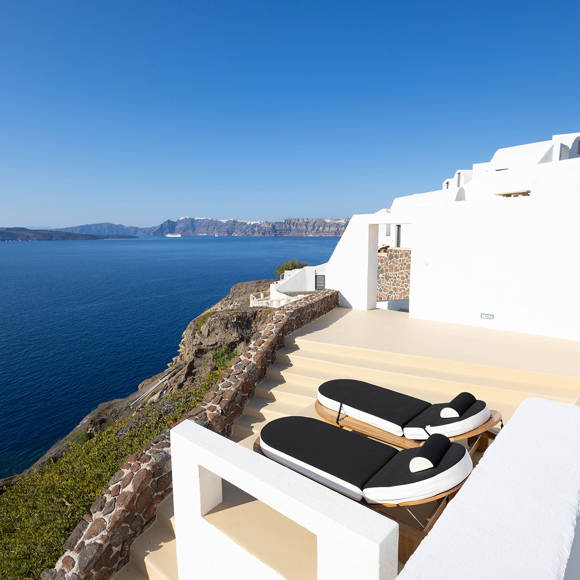 Grand Ambassador Santorini Serenity Two Bedroom Suite terrace with designer sun loungers, caldera view, and white Cycladic architecture