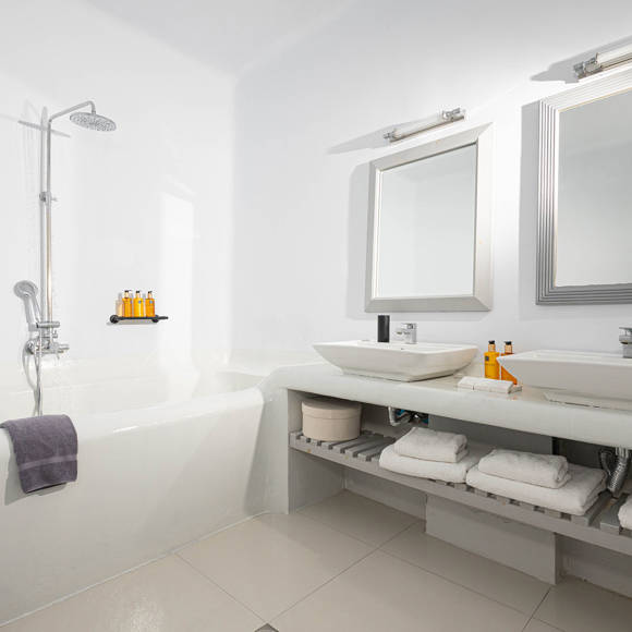 Grand Ambassador Santorini Serenity Two Bedroom Suite bathroom with built-in tub, twin sinks, rainfall shower, and luxury amenities