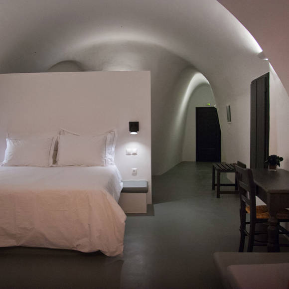 Grand Ambassador Santorini Infinity Cave Suite cozy vaulted bedroom with luxury bedding