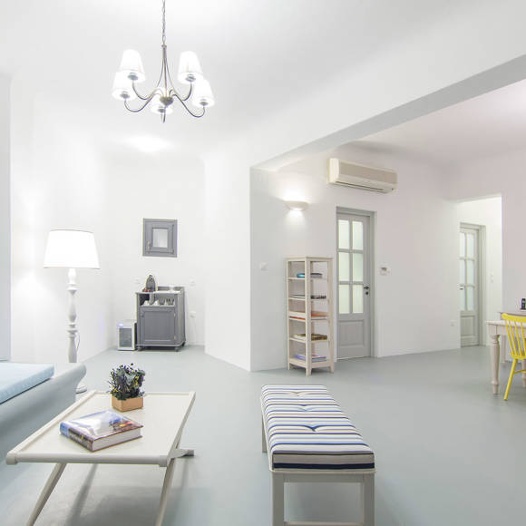 Grand Ambassador Santorini Villa stylish living room with blue built-in sofa, coffee table, and open-plan layout